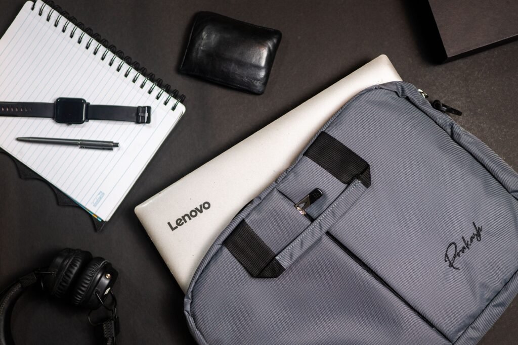 Top view of modern office essentials including a laptop, notebook, and accessories.